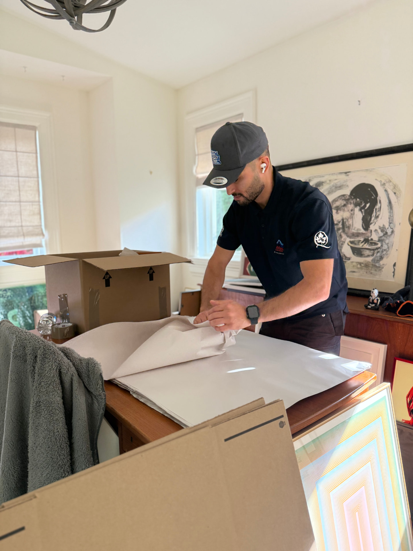 Professional packers wrapping glassware and artwork in a North Vancouver home